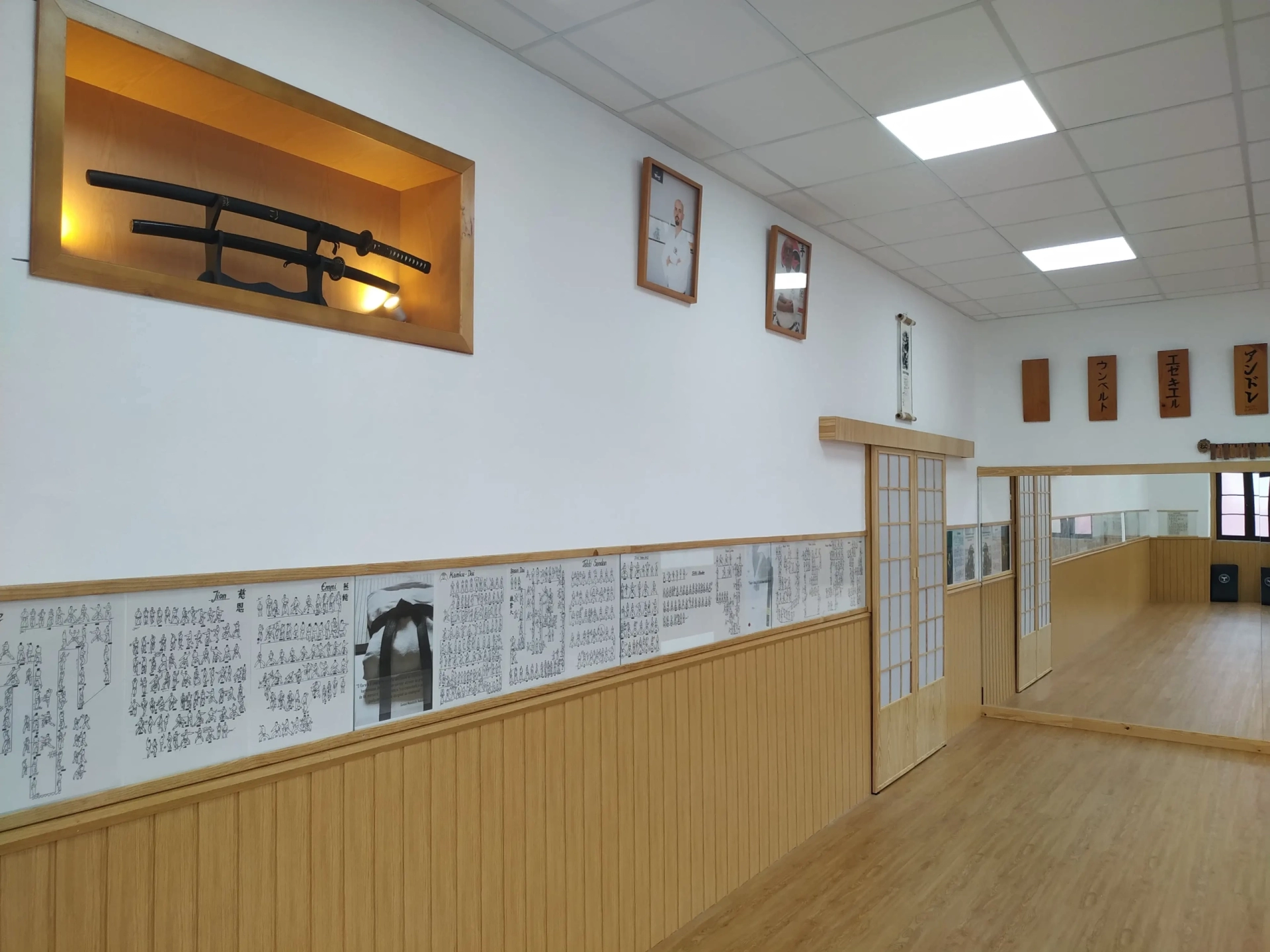 Interior do dojo do Clube de Karaté Alcanena, com vitrine de katana e diplomas na parede