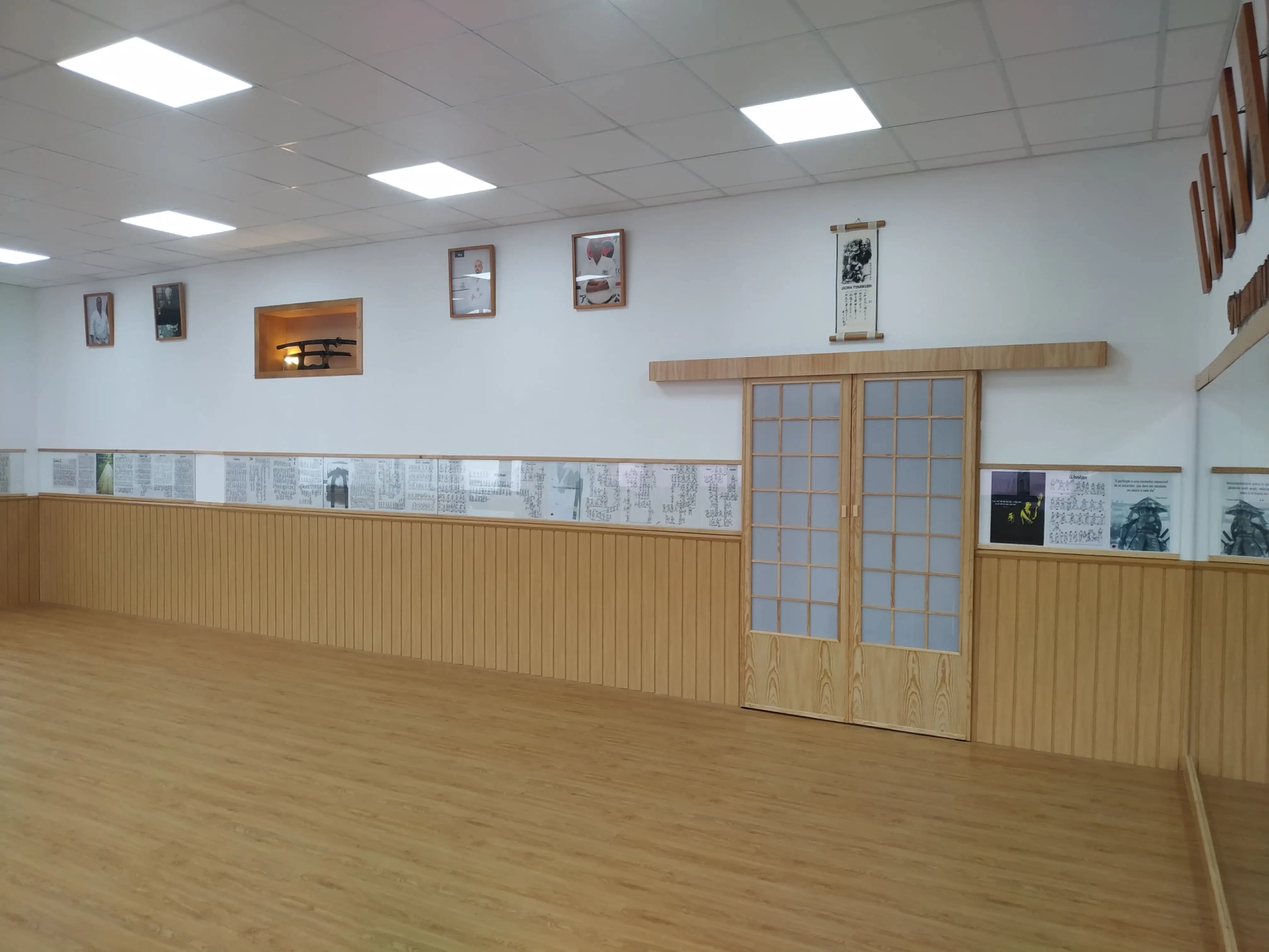 Corredor do dojo do Clube de Karaté Alcanena com molduras e quadros tradicionais na parede